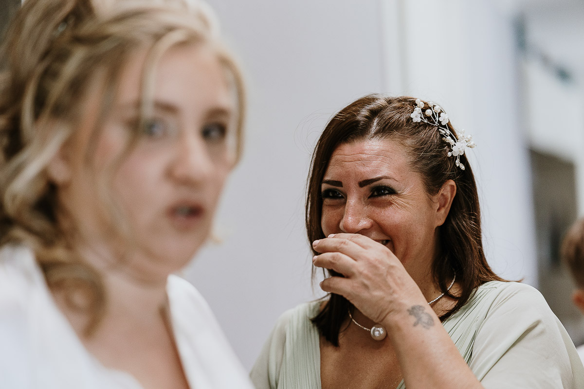 Fotografo Matrimonio in Piemonte. Preparazione a Moncucco Torinese. Damigella della sposa ride.