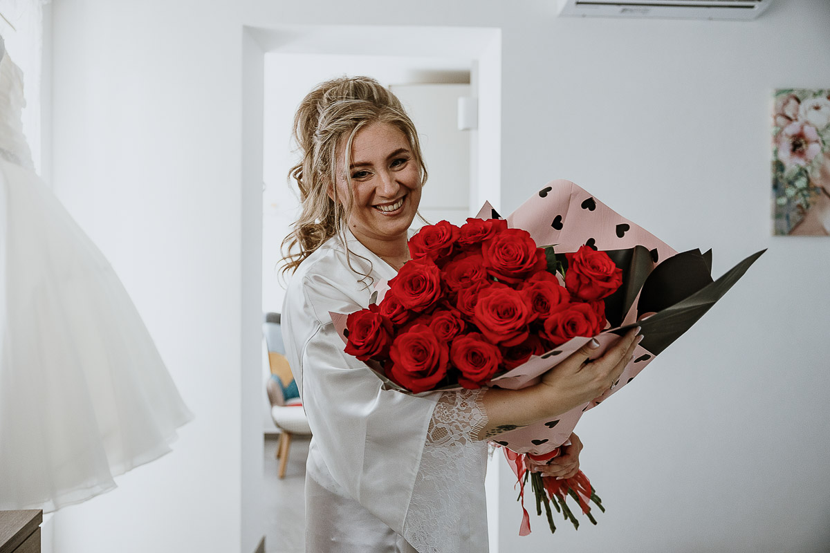 Fotografo Matrimonio in Piemonte. Preparazione a Moncucco Torinese. Sposa con il mazzo di rose rosse dono dello sposo.