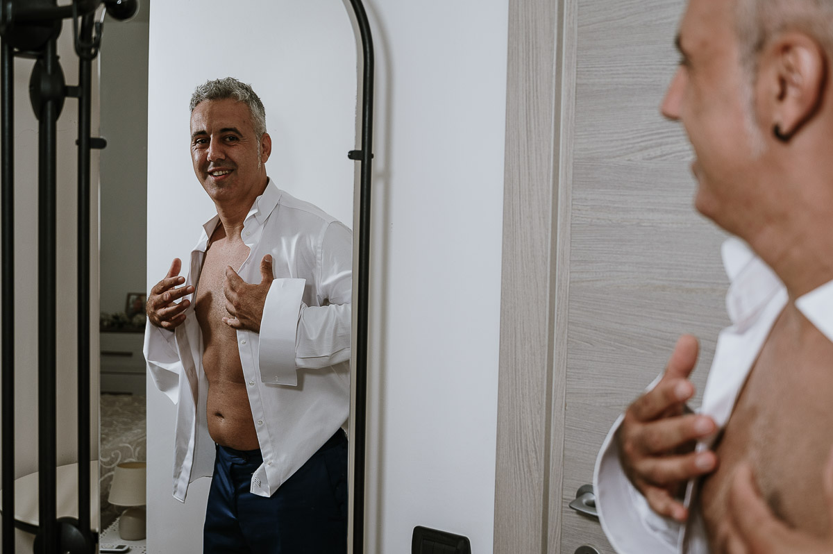 Fotografo Matrimonio in Piemonte. Preparazione a Moncucco Torinese. Lo sposo si mette la camicia.