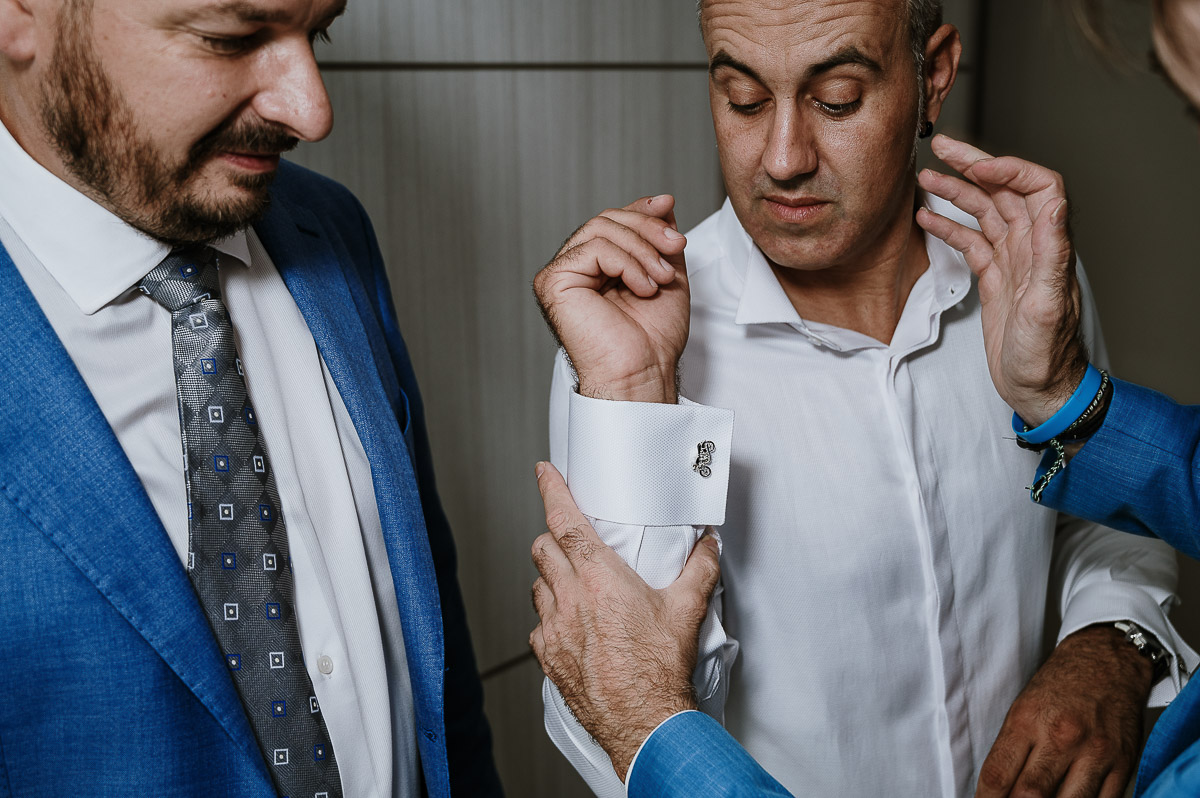 Fotografo Matrimonio in Piemonte. Preparazione a Moncucco Torinese. Il testimone mostra il gemello dello sposo che rappresenta una motocicletta.
