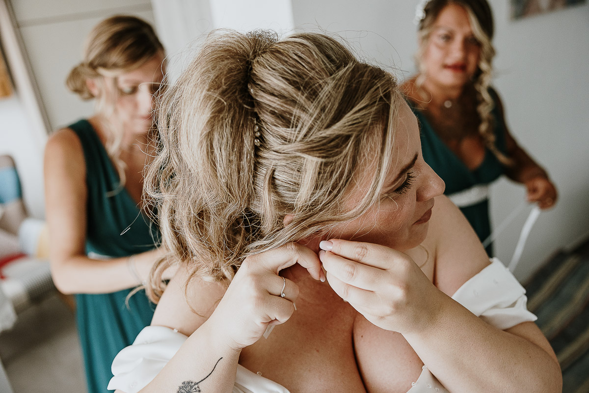 Fotografo Matrimonio in Piemonte. Preparazione a Moncucco Torinese. la sposa indossa gli orecchini.