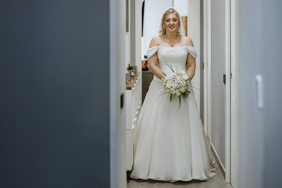 Fotografo Matrimonio in Piemonte. Preparazione a Moncucco Torinese. ritratto della sposa vestita e con il bouquet a figura intera.