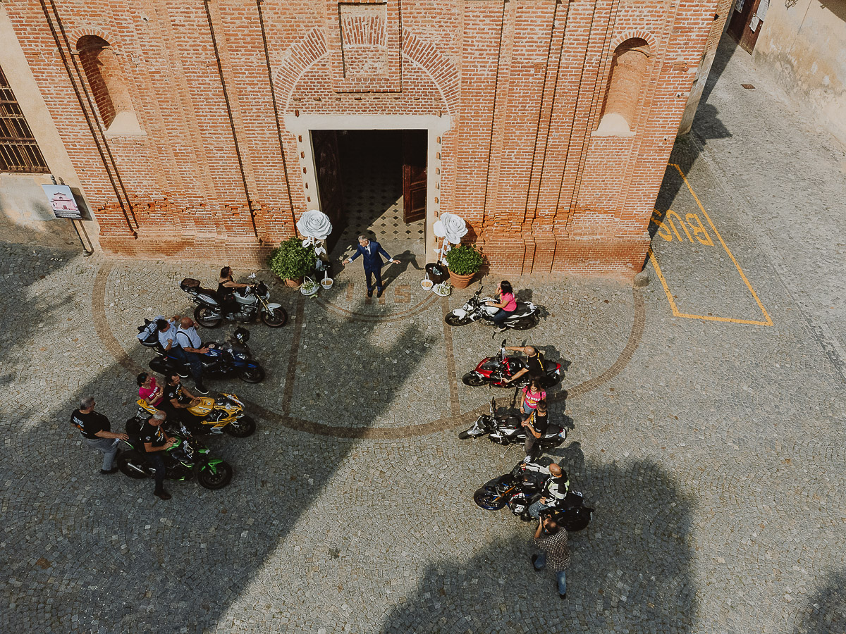 Fotografo Matrimonio in Piemonte. Cerimonia a Moriondo Torinese. Sposo davanti alla chiesa con la parata di motociclisti.
