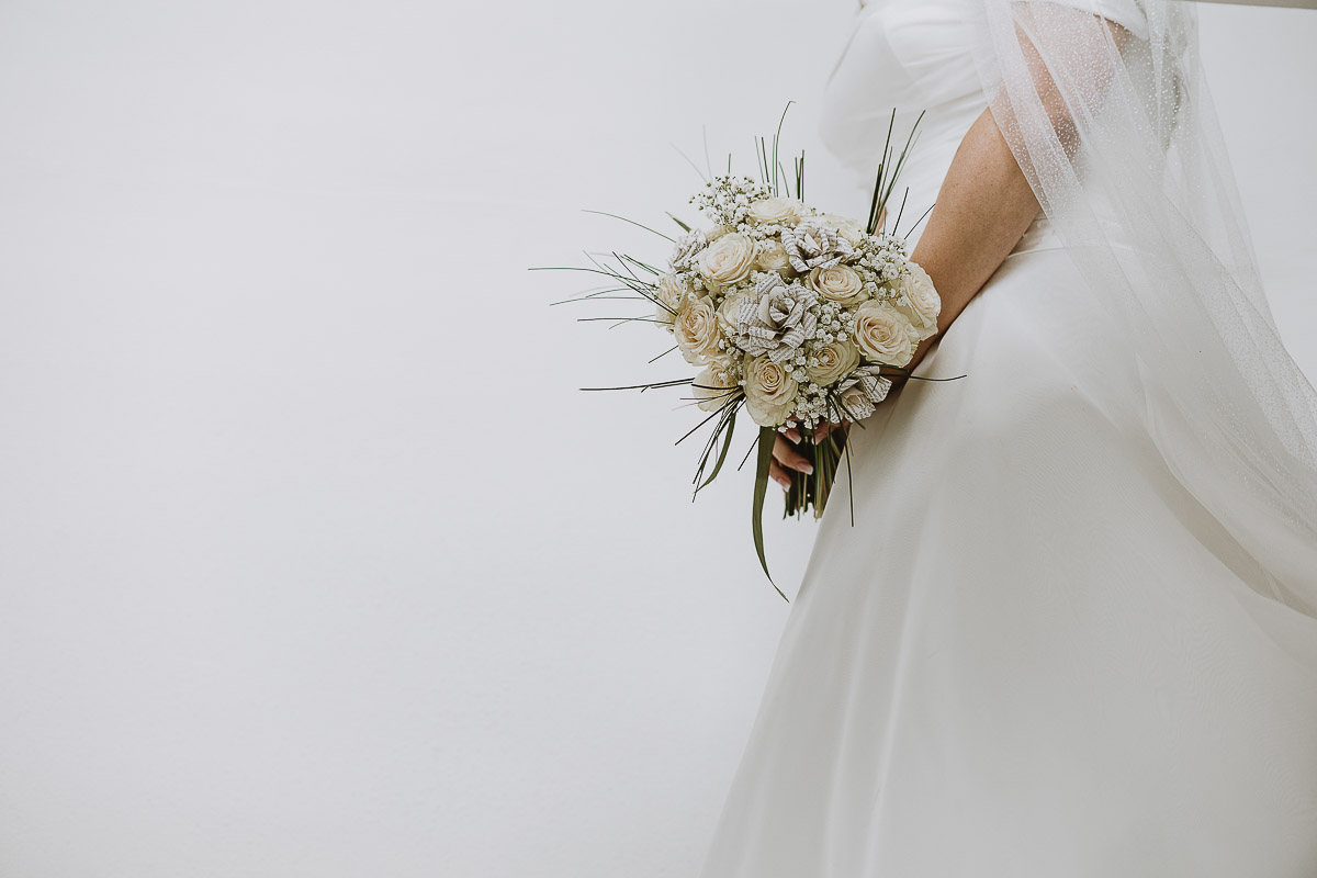 Fotografo Matrimonio in Piemonte. Preparazione a Moncucco Torinese. La sposa scende le scale dettaglio del bouquet.