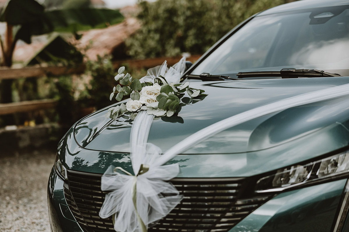 Fotografo Matrimonio in Piemonte. Preparazione a Moncucco Torinese. dettaglio della parte anteriore dell'auto con i fiori.