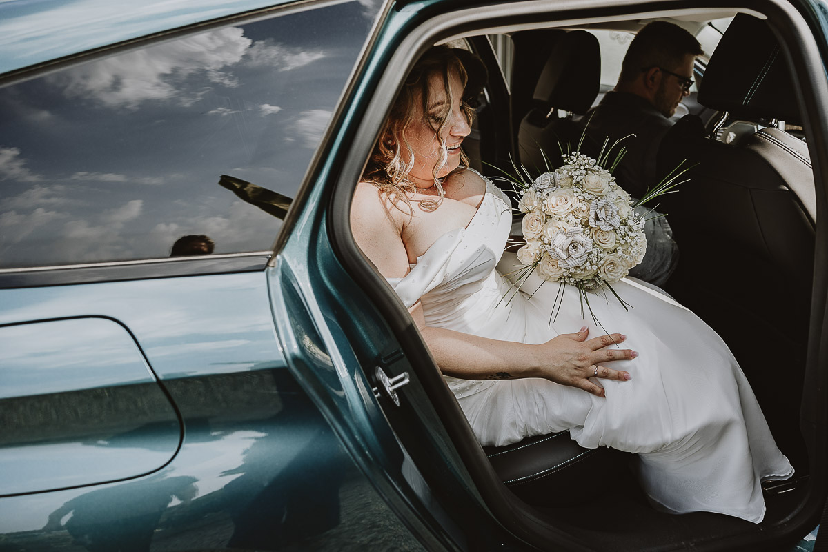 Fotografo Matrimonio in Piemonte. Cerimonia nella chiesa di San Giovanni Battista di Moriondo Torinese. Sposa nell'auto