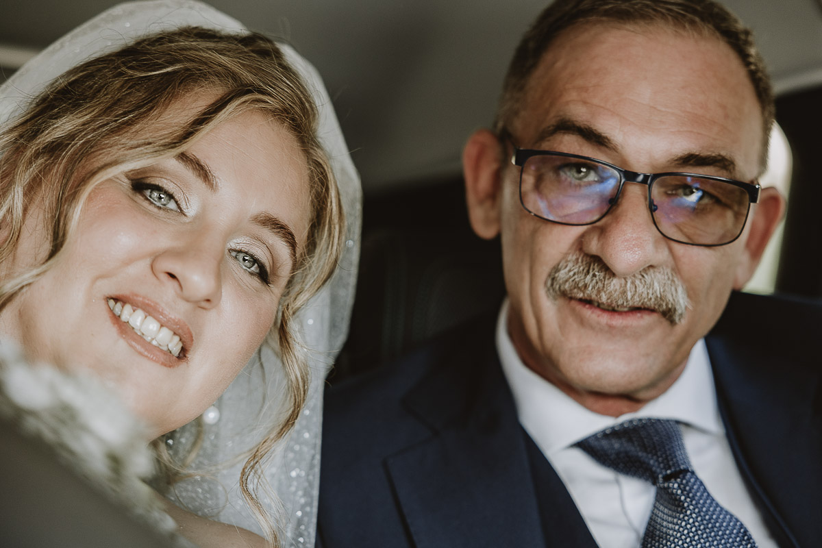 Fotografo Matrimonio in Piemonte. Cerimonia nella chiesa di San Giovanni Battista di Moriondo Torinese. Sposa in auto con il padre.