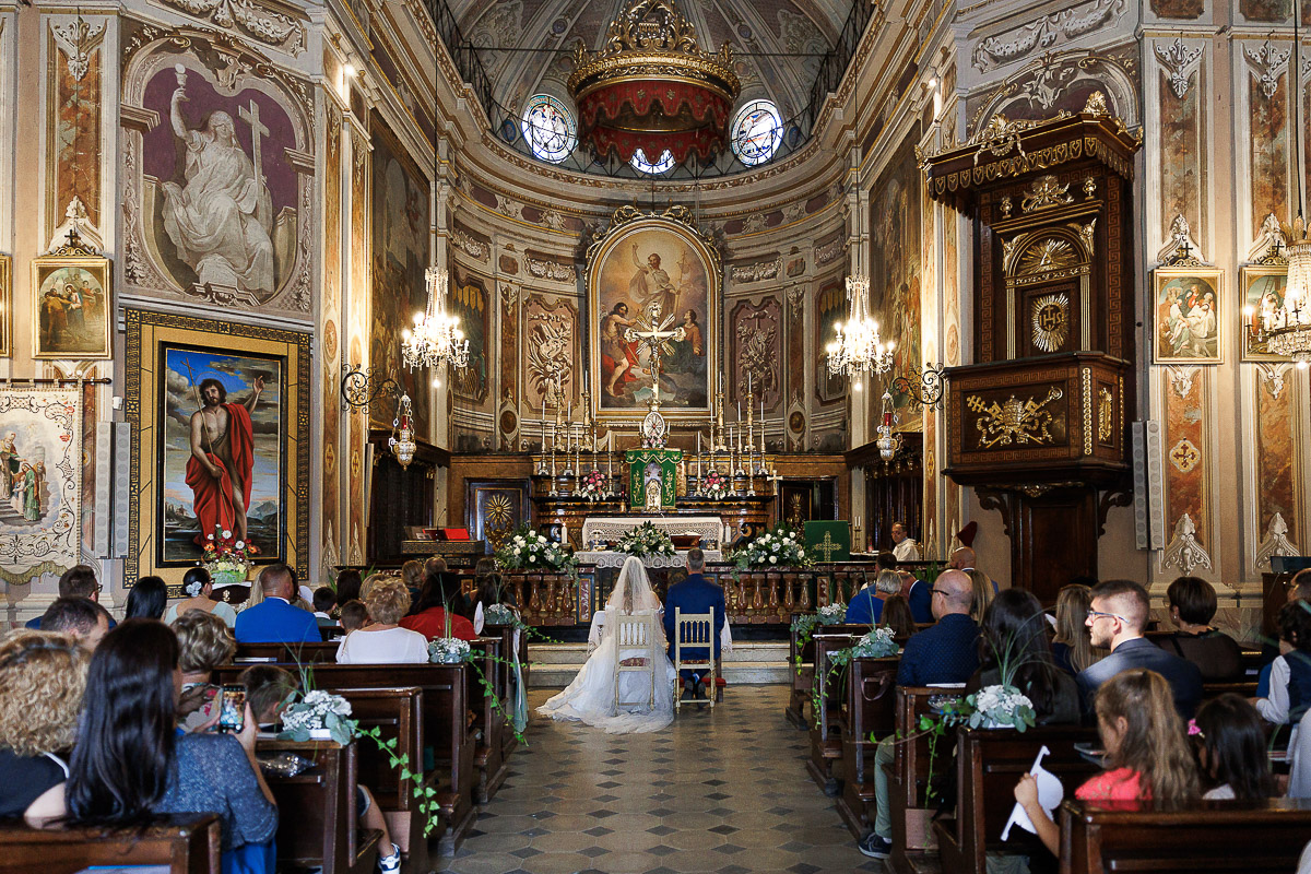 Fotografo Matrimonio in Piemonte. Cerimonia nella chiesa di San Giovanni Battista di Moriondo Torinese. Veduta della chiesa e degli sposi da dietro.