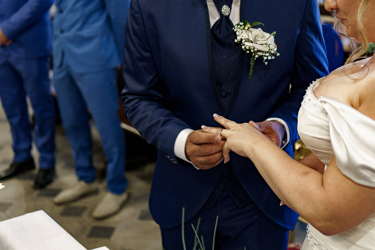 Fotografo Matrimonio in Piemonte. Cerimonia nella chiesa di San Giovanni Battista di Moriondo Torinese. Sposo mette l'anello alla sposa.