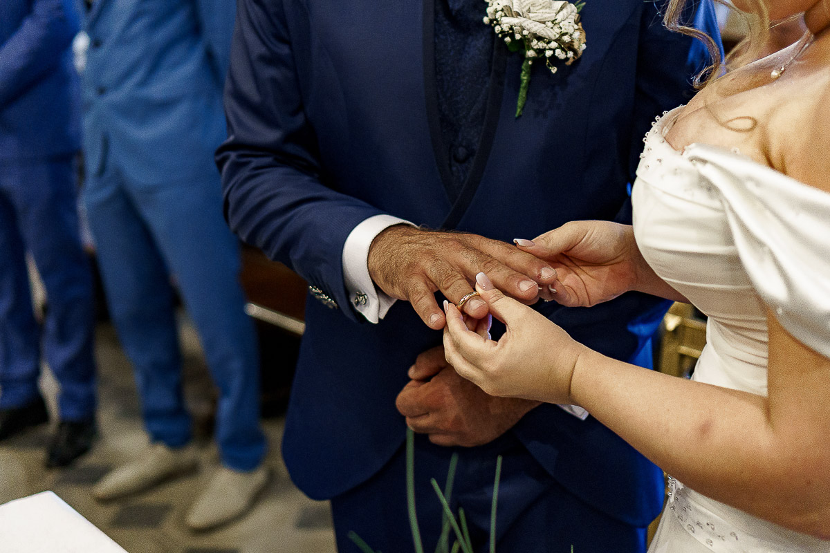 Fotografo Matrimonio in Piemonte. Cerimonia nella chiesa di San Giovanni Battista di Moriondo Torinese. Sposa mette l'anello allo sposo.