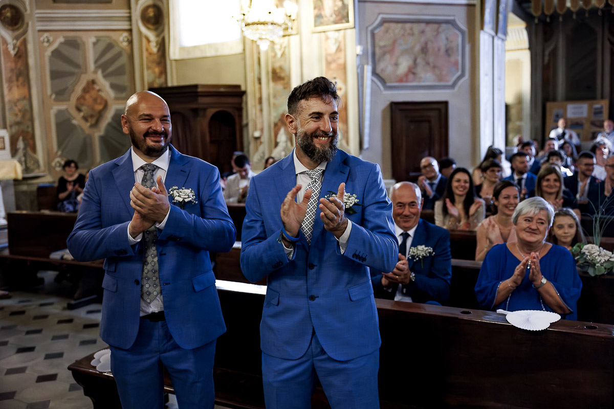 Fotografo Matrimonio in Piemonte. Cerimonia nella chiesa di San Giovanni Battista di Moriondo Torinese. Testimoni applaudono.