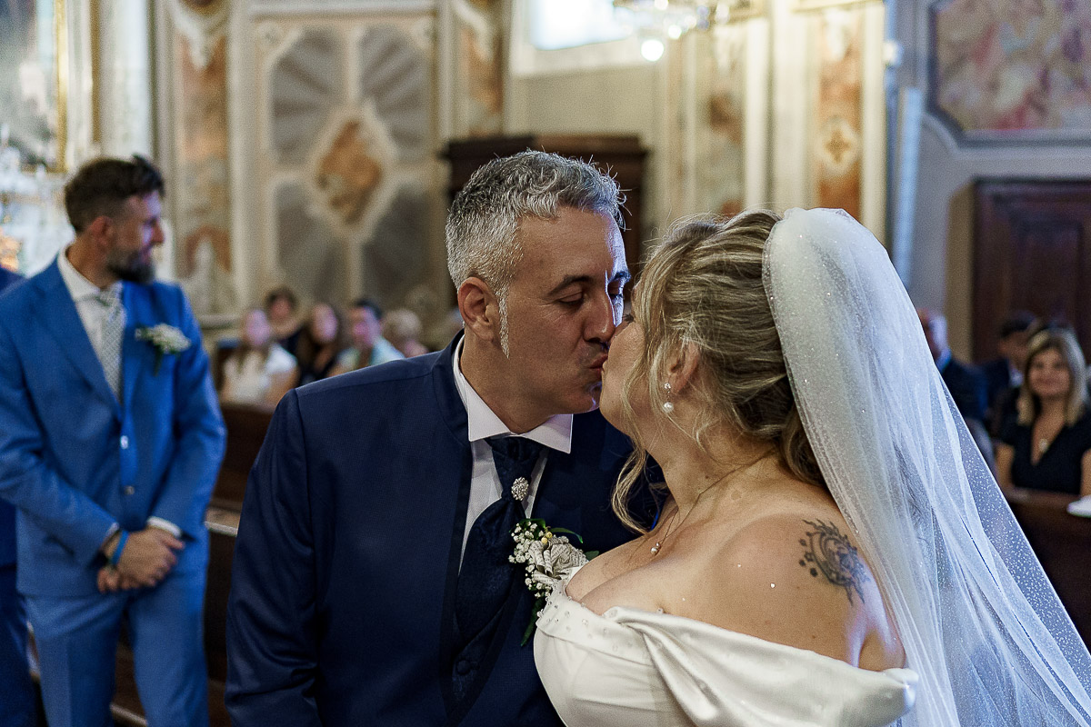 Fotografo Matrimonio in Piemonte. Cerimonia nella chiesa di San Giovanni Battista di Moriondo Torinese. Bacio degli sposi.