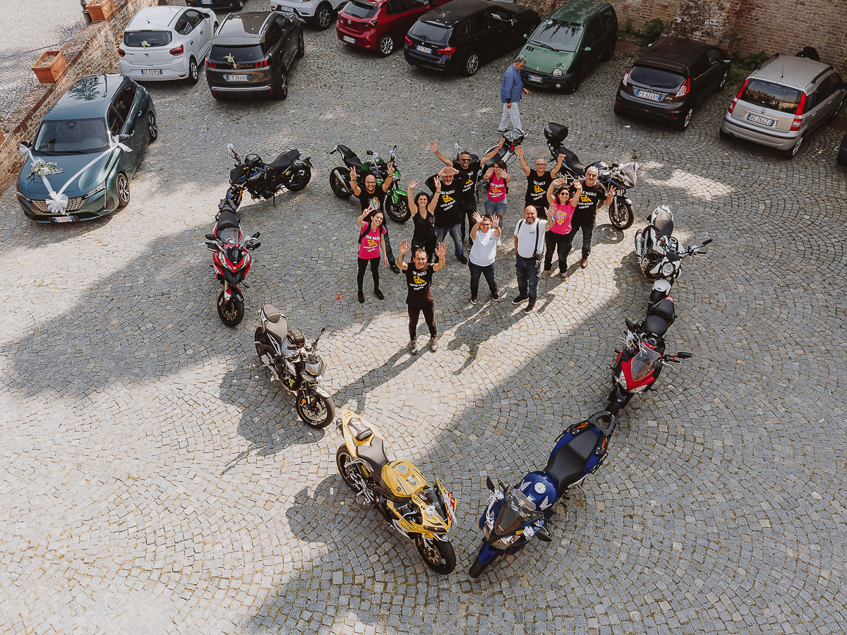 Fotografo Matrimonio in Piemonte. Cerimonia nella chiesa di San Giovanni Battista di Moriondo Torinese. Fuori dalla chiesa gli amici ciclisti creano un cuore con le moto. Foto aerea dal drone.