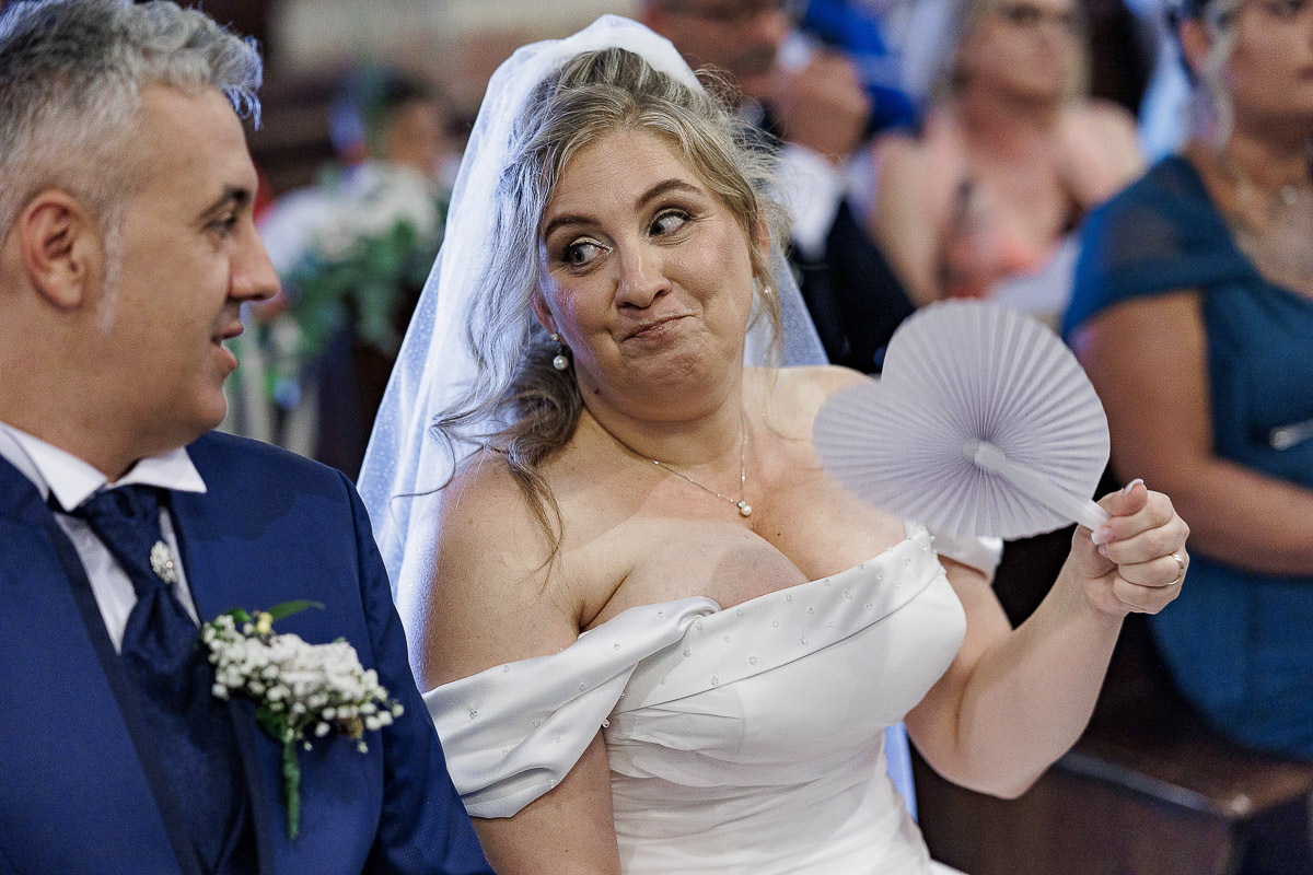 Fotografo Matrimonio in Piemonte. Cerimonia nella chiesa di San Giovanni Battista di Moriondo Torinese. la sposa con un'espressione buffa.