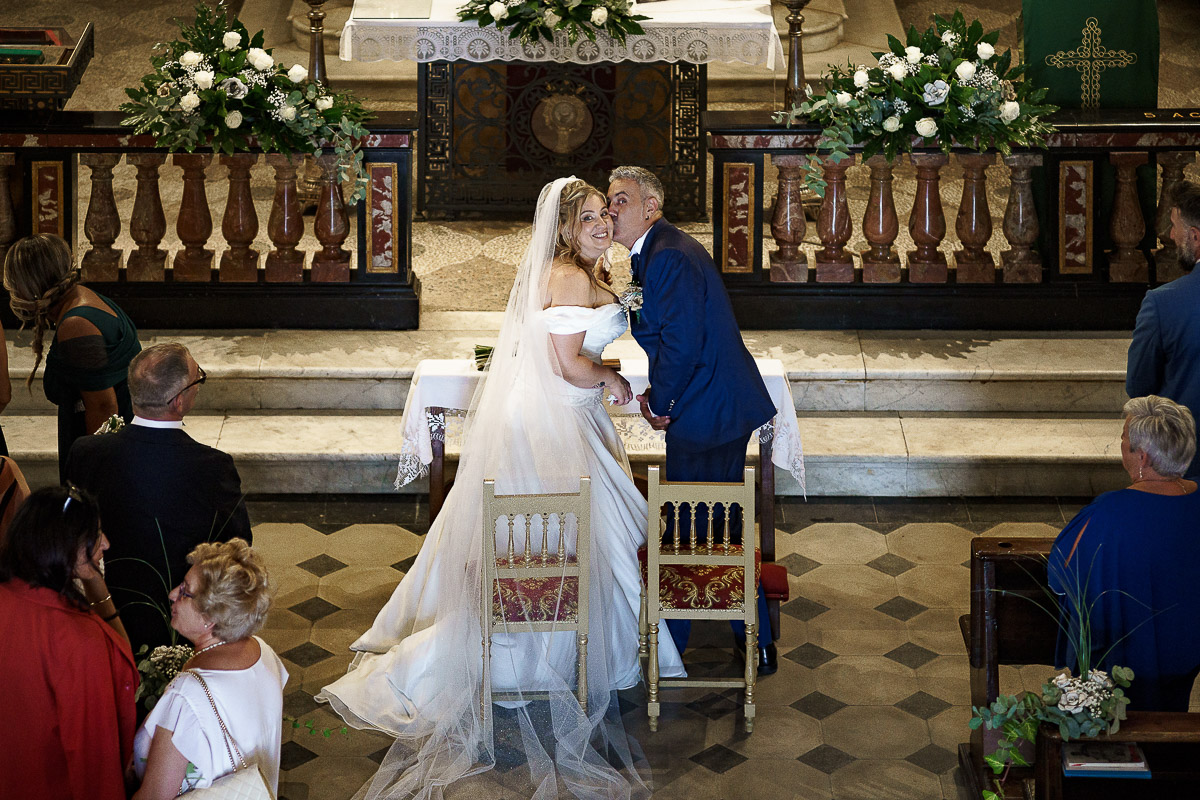 Fotografo Matrimonio in Piemonte. Cerimonia nella chiesa di San Giovanni Battista di Moriondo Torinese. Sposi guancia guancia. Foto scattata dall'alto dall'Organo.