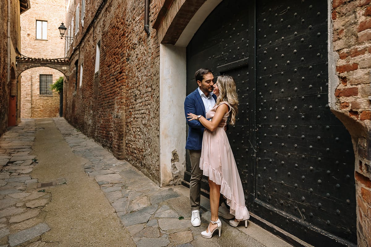 Pre-wedding a Chieri. Shary e Claudio abbracciati davanti ad un antico portone di legno si guardano.