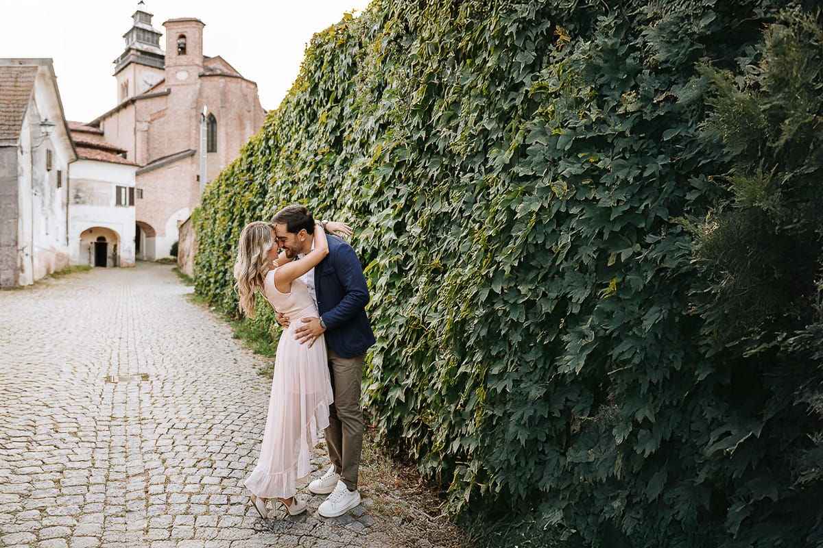 Pre-wedding a Chieri. Shary e Claudio si guardano. Sullo sfondo la chiesa medievale di San Giorgio.