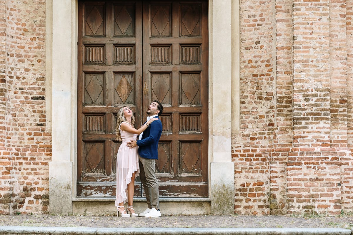 Pre-wedding a Chieri. Shary e Claudio nel piazzale della Chiesa di San Giorgio, il punto più alto e panoramico della città. Shary e Claudio davanti al portone della chiesa. guardano in su.