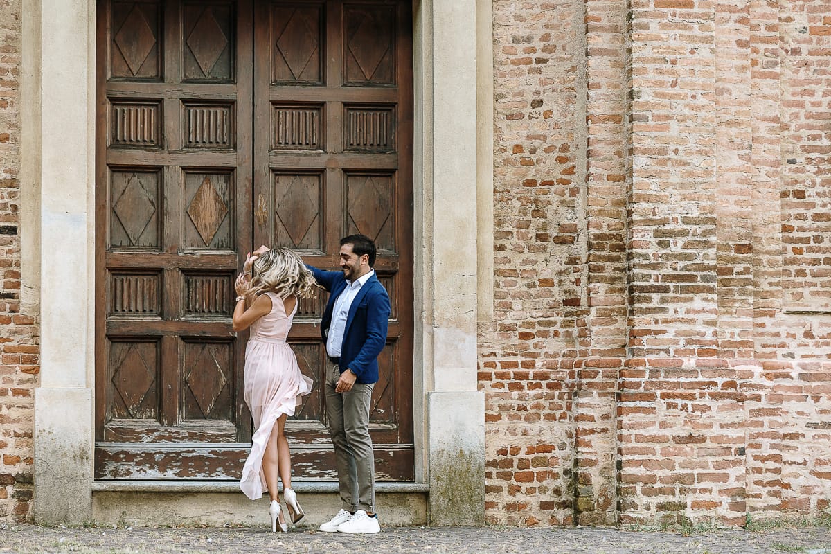 Pre-wedding a Chieri. Shary e Claudio nel piazzale della Chiesa di San Giorgio, il punto più alto e panoramico della città. Shary e Claudio davanti al portone della chiesa. Claudio fa fare una piroetta a Shary