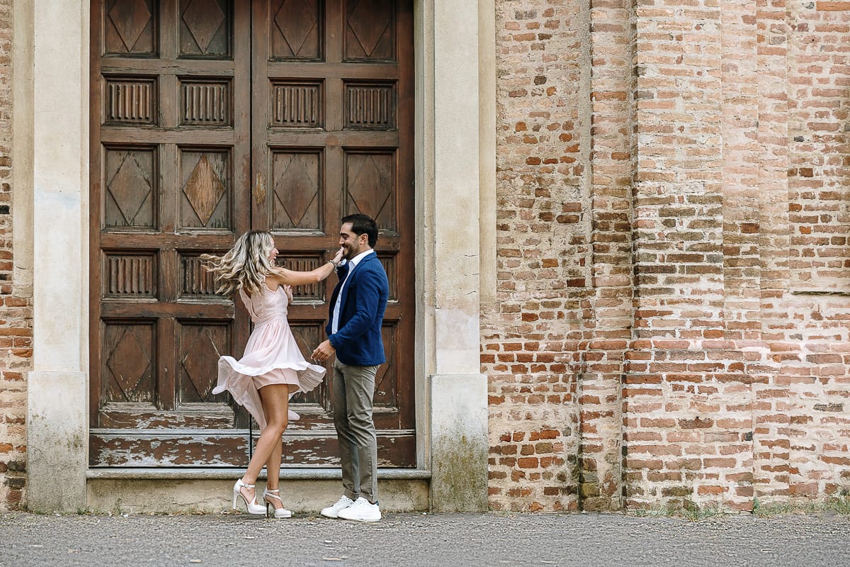 Pre-wedding a Chieri. Shary e Claudio nel piazzale della Chiesa di San Giorgio, il punto più alto e panoramico della città. Shary e Claudio davanti al portone della chiesa. Shary fa una piroetta.