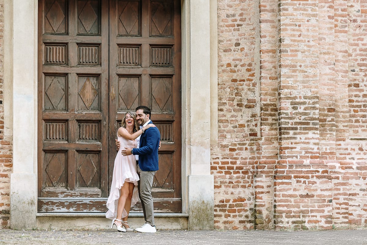Pre-wedding a Chieri. Shary e Claudio nel piazzale della Chiesa di San Giorgio, il punto più alto e panoramico della città. Shary e Claudio davanti al portone della chiesa. si guardano.