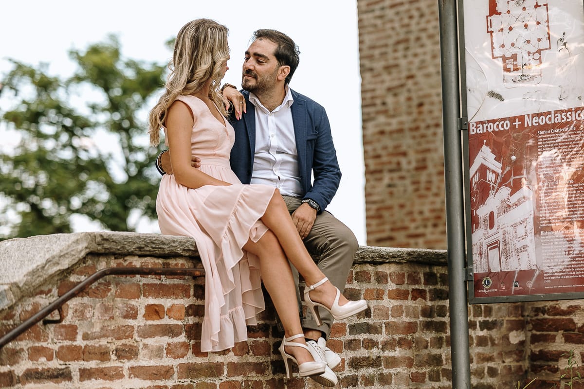 Pre-wedding a Chieri. Shary e Claudio nel piazzale della Chiesa di San Giorgio, il punto più alto e panoramico della città. Shary e Claudio davanti al portone della chiesa. seduti su di un muretto