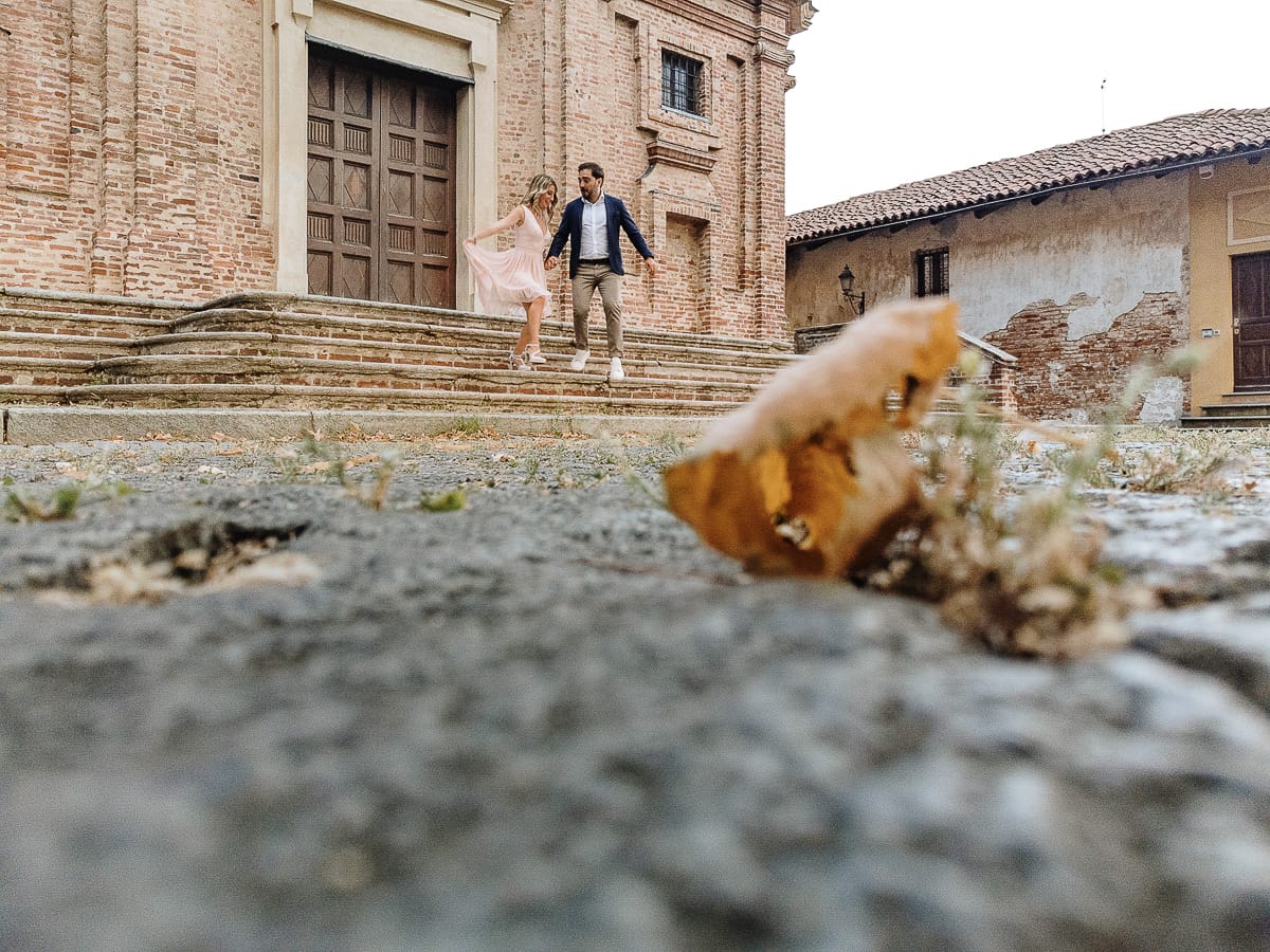 Pre-wedding a Chieri. Shary e Claudio nel piazzale della Chiesa di San Giorgio, il punto più alto e panoramico della città. Shary e Claudio davanti al portone della chiesa scendono le scale. Foto dal drone posto per terra.