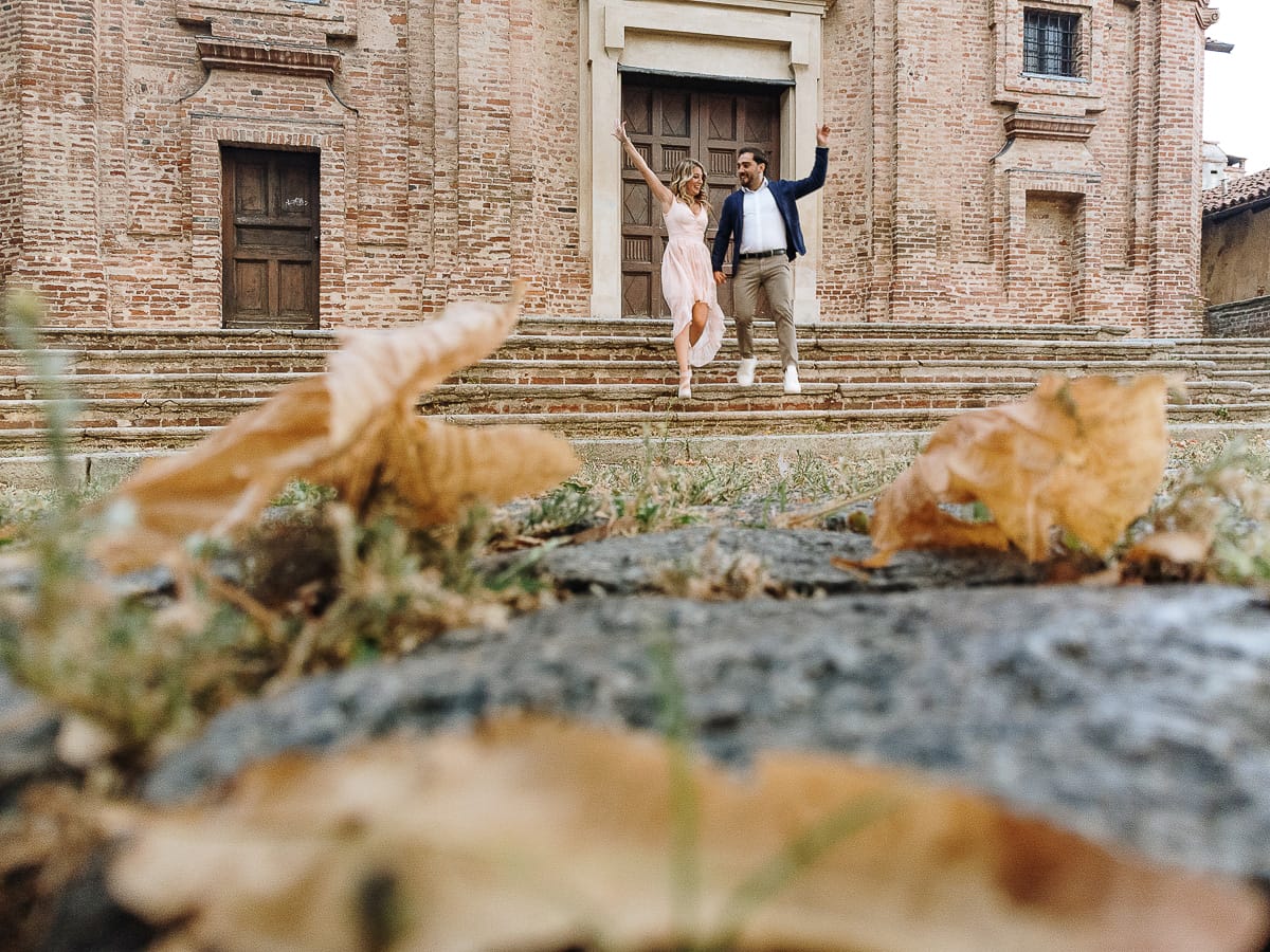 Pre-wedding a Chieri. Shary e Claudio nel piazzale della Chiesa di San Giorgio, il punto più alto e panoramico della città. Shary e Claudio davanti al portone della chiesa scendono le scale. Foto dal drone posto per terra.