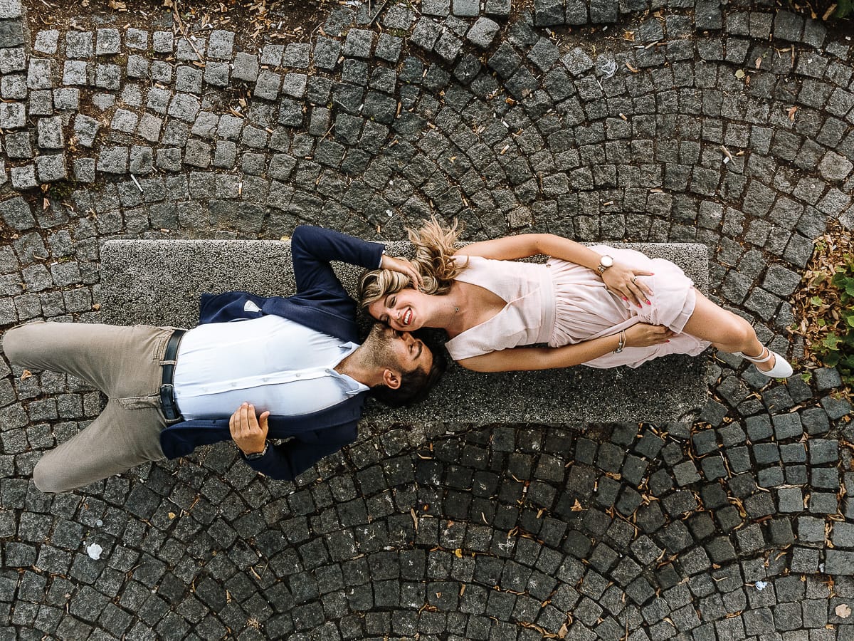 Pre-wedding a Chieri. Shary e Claudio nel piazzale della Chiesa di San Giorgio, il punto più alto e panoramico della città. Shary e Claudio sono sdraiati su di una panchina nel piazzale della chiesa di San Giorgio. Foto dal drone.