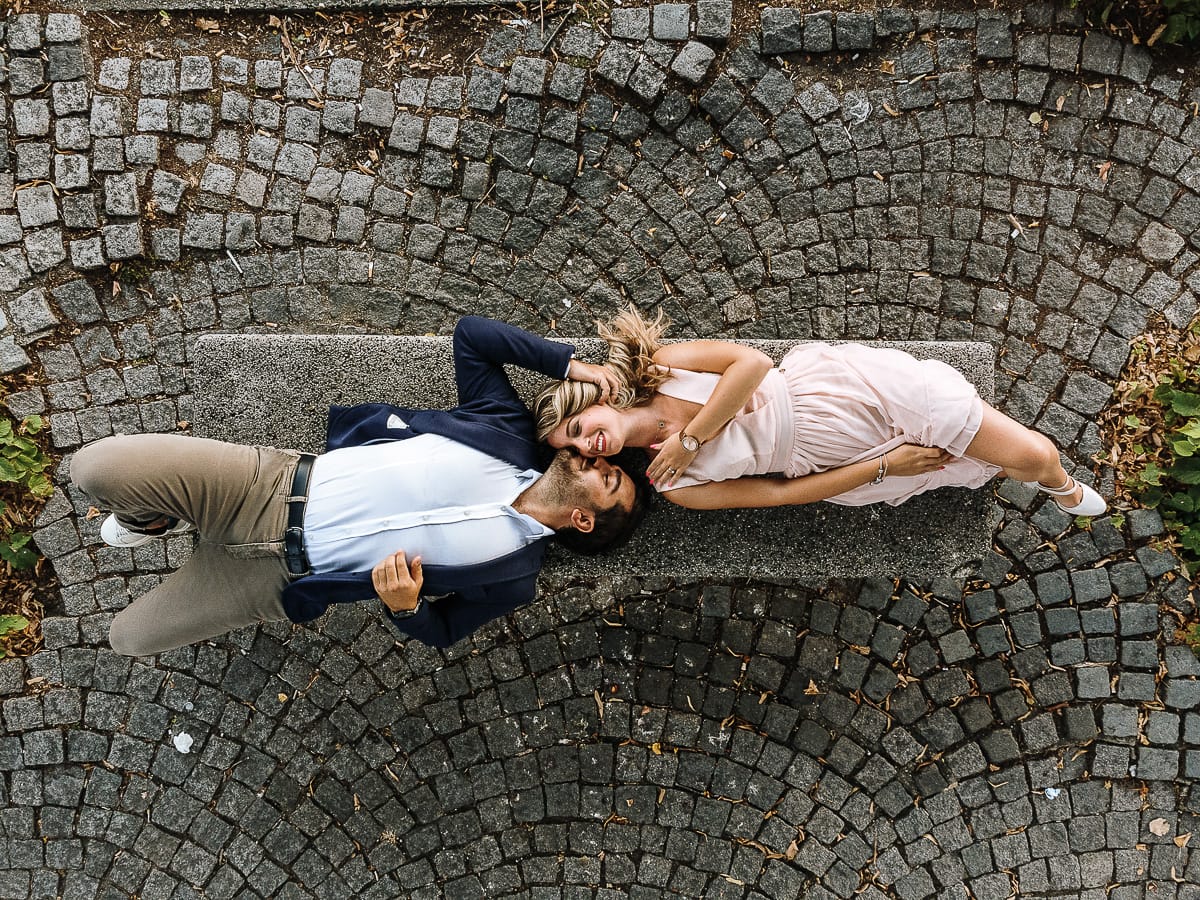 Pre-wedding a Chieri. Shary e Claudio nel piazzale della Chiesa di San Giorgio, il punto più alto e panoramico della città. Shary e Claudio sono sdraiati su di una panchina nel piazzale della chiesa di San Giorgio. Foto