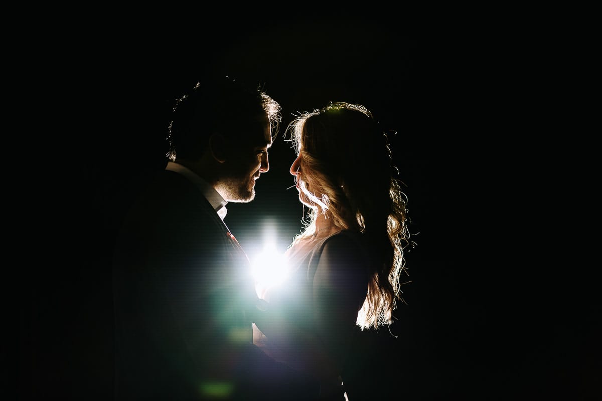 Pre-wedding a Chieri. Shary e Claudio abbracciati davanti all'ingresso delle ex-carceri medievali. Flash off-camera dietro di loro che crea rim light. d flare.