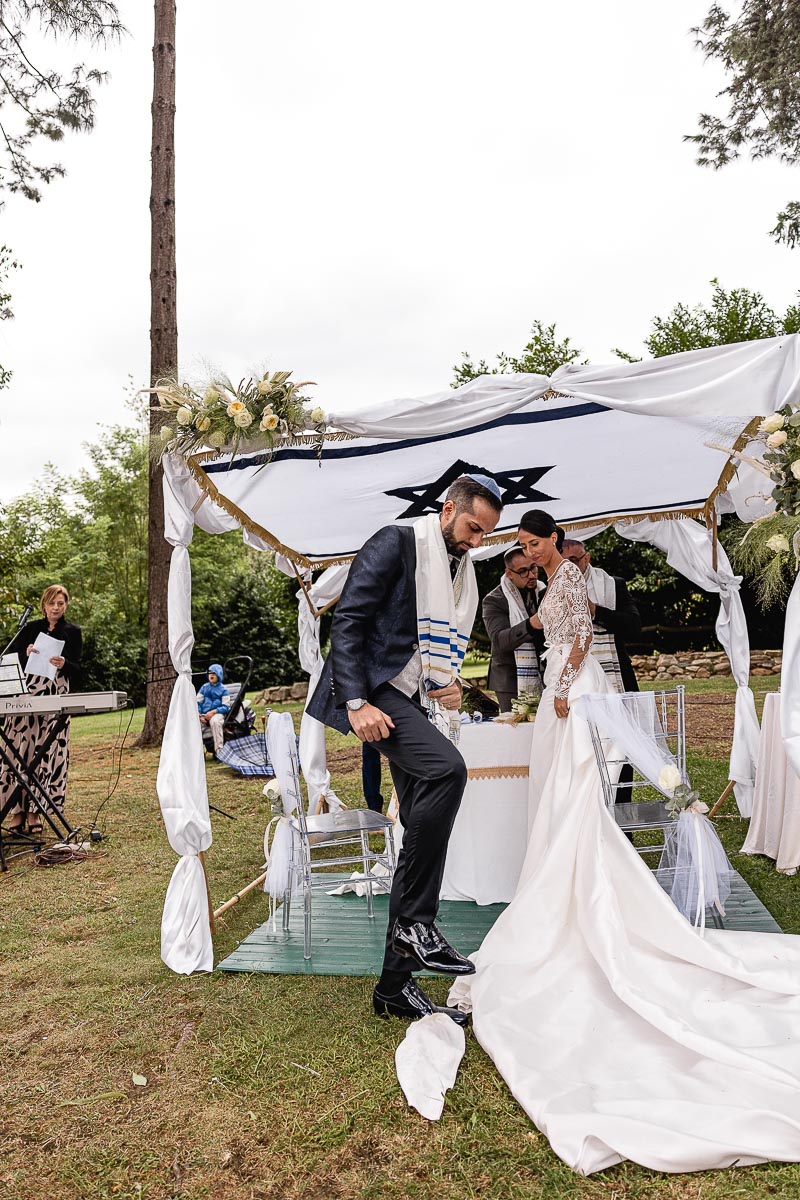 Fotografo Matrimonio Lago di Viverone, Tenuta Variselle. Cerimonia religiosa secondo il rito della Chiesa di Antiochia. Sposo si appresta a rompere il bicchiere secondo la tradizione ebraica.