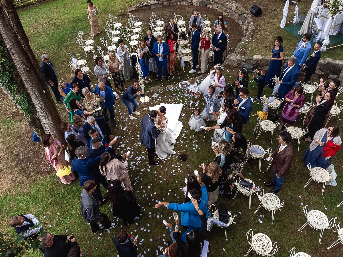 Fotografo Matrimonio Lago di Viverone, Tenuta Variselle. Cerimonia religiosa secondo il rito della Chiesa di Antiochia. Uscita degli sposi e lancio dei petali. Bacio degli sposi dal drone.