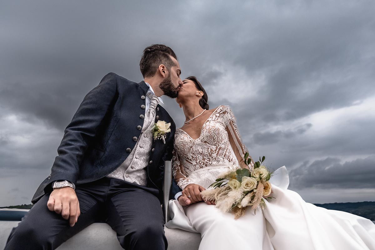 Fotografo Matrimonio Lago di Viverone, Tenuta Variselle. Fotografia di coppia degli sposi. Sposi sul motoscafo. Bacio.