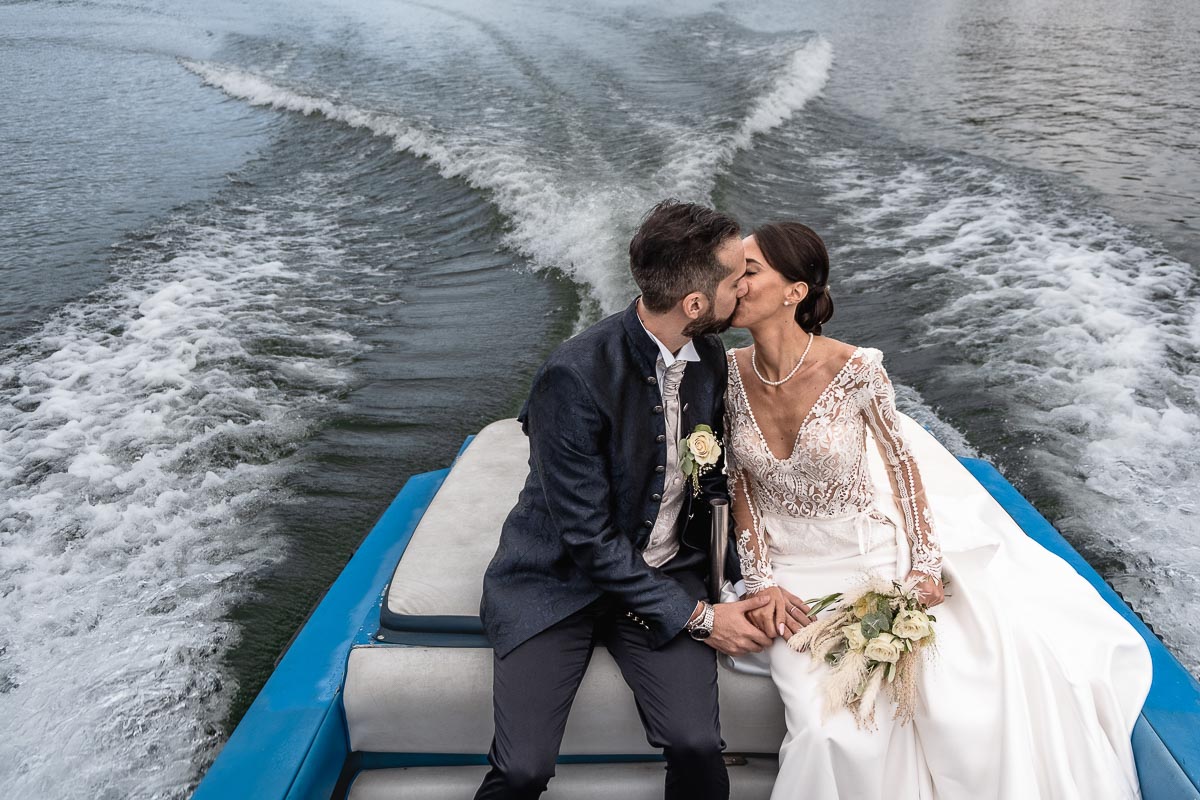 Fotografo Matrimonio Lago di Viverone, Tenuta Variselle. Fotografia di coppia degli sposi. Sposi sul motoscafo. Bacio