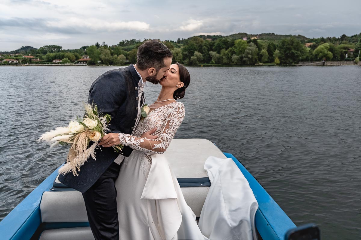 Fotografo Matrimonio Lago di Viverone, Tenuta Variselle. Fotografia di coppia degli sposi. Sposi sul motoscafo. Bacio in piedi.