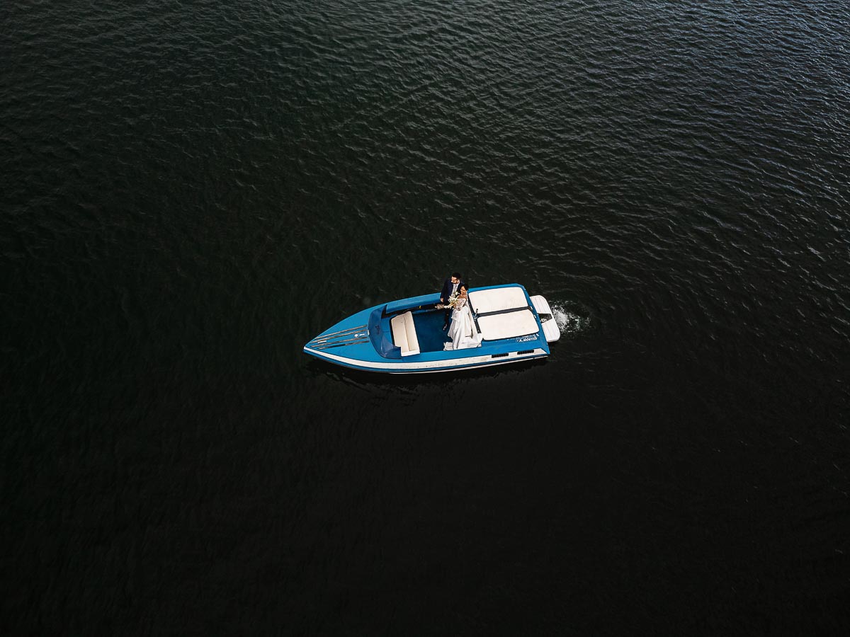 Fotografo Matrimonio Lago di Viverone, Tenuta Variselle. Fotografia di coppia degli sposi. Sposi sul motoscafo. Foto dal drone . motoscafo fermo in mezzo al lago.