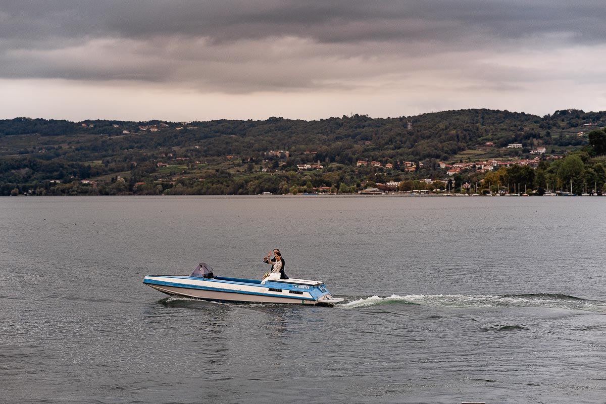 Fotografo Matrimonio Lago di Viverone, Tenuta Variselle. Fotografia di coppia degli sposi. Sposi sul motoscafo. Foto dal pontile.