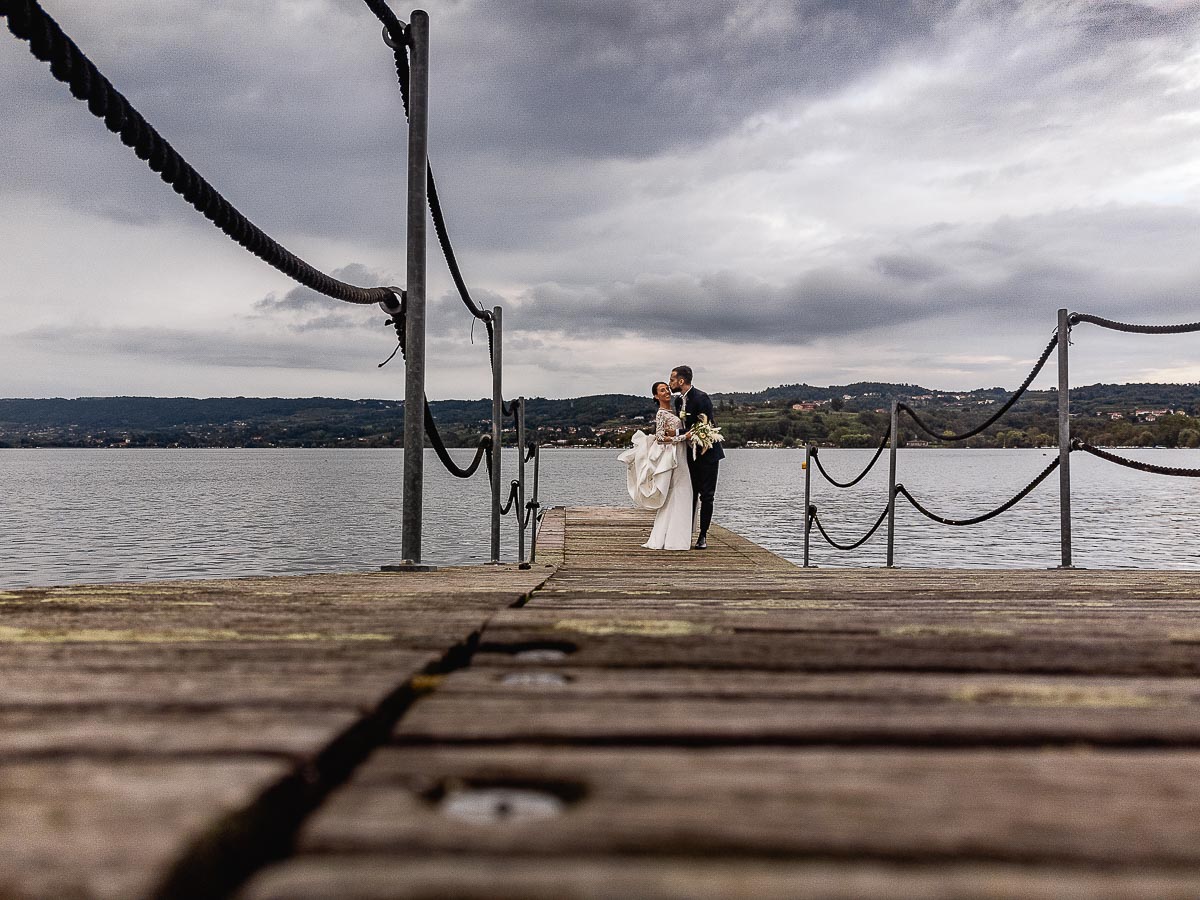 Fotografo Matrimonio Lago di Viverone, Tenuta Variselle. Fotografia di coppia degli sposi. Bacio degli sposi sul pontile. Foto dal drone, ripresa dal basso.