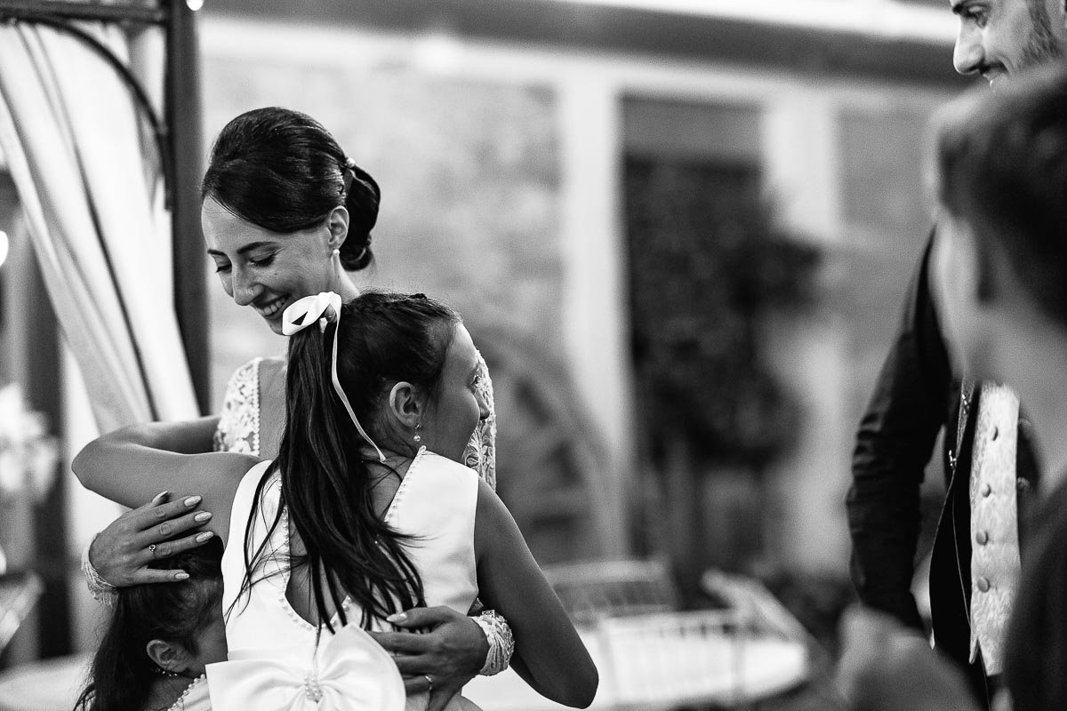 Fotografo Matrimonio Lago di Viverone, Tenuta Variselle. Damigellina abbraccia la sposa.