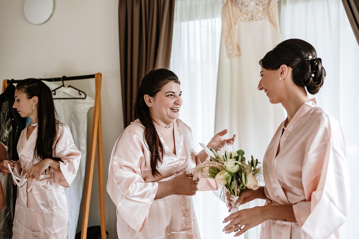Fotografo Matrimonio Lago di Viverone, Tenuta Variselle. Preparazione della sposa. Sposa mostra il bouquet alla damigella.