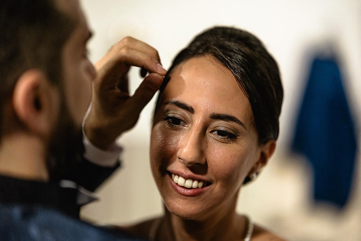 Fotografo Matrimonio Lago di Viverone, Tenuta Variselle. Ricevimento. Sposo sistema i capelli alla sposa.