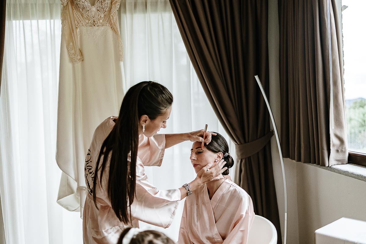Fotografo Matrimonio Lago di Viverone, Tenuta Variselle. Preparazione della sposa. Damigella trucca la sposa