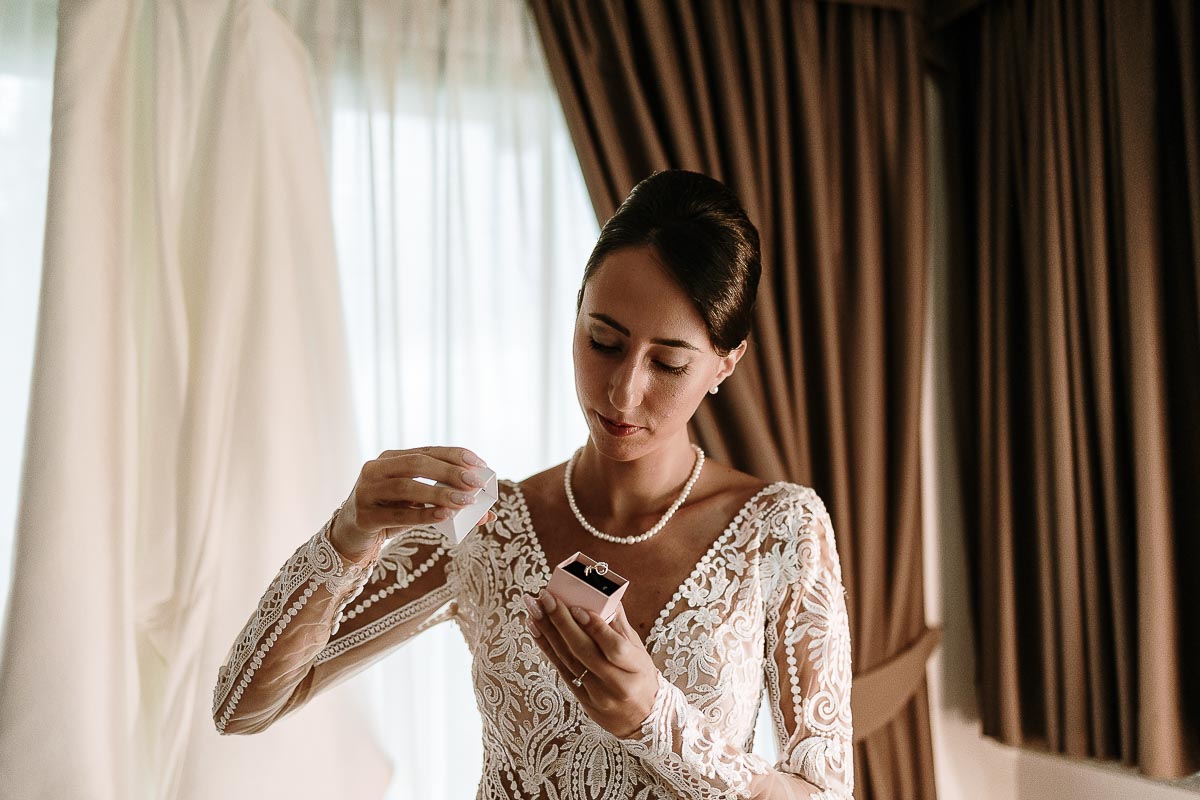 Fotografo Matrimonio Lago di Viverone, Tenuta Variselle. Preparazione della sposa. Sposa mostra il ciondolo regalato dalla sorella.