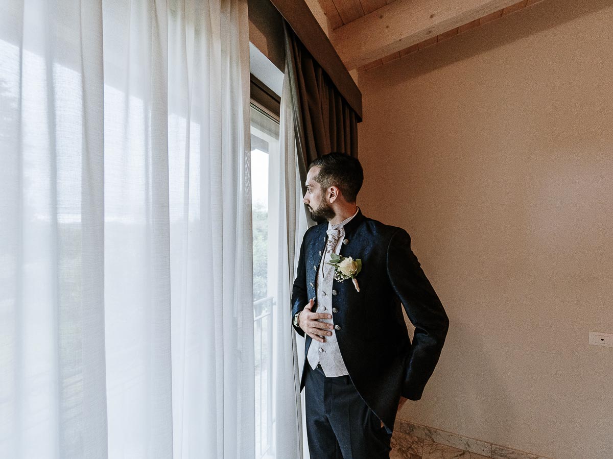 Fotografo Matrimonio Lago di Viverone, Tenuta Variselle. Preparazione dello sposo. Ritratto dello sposo vicino alla finestra.