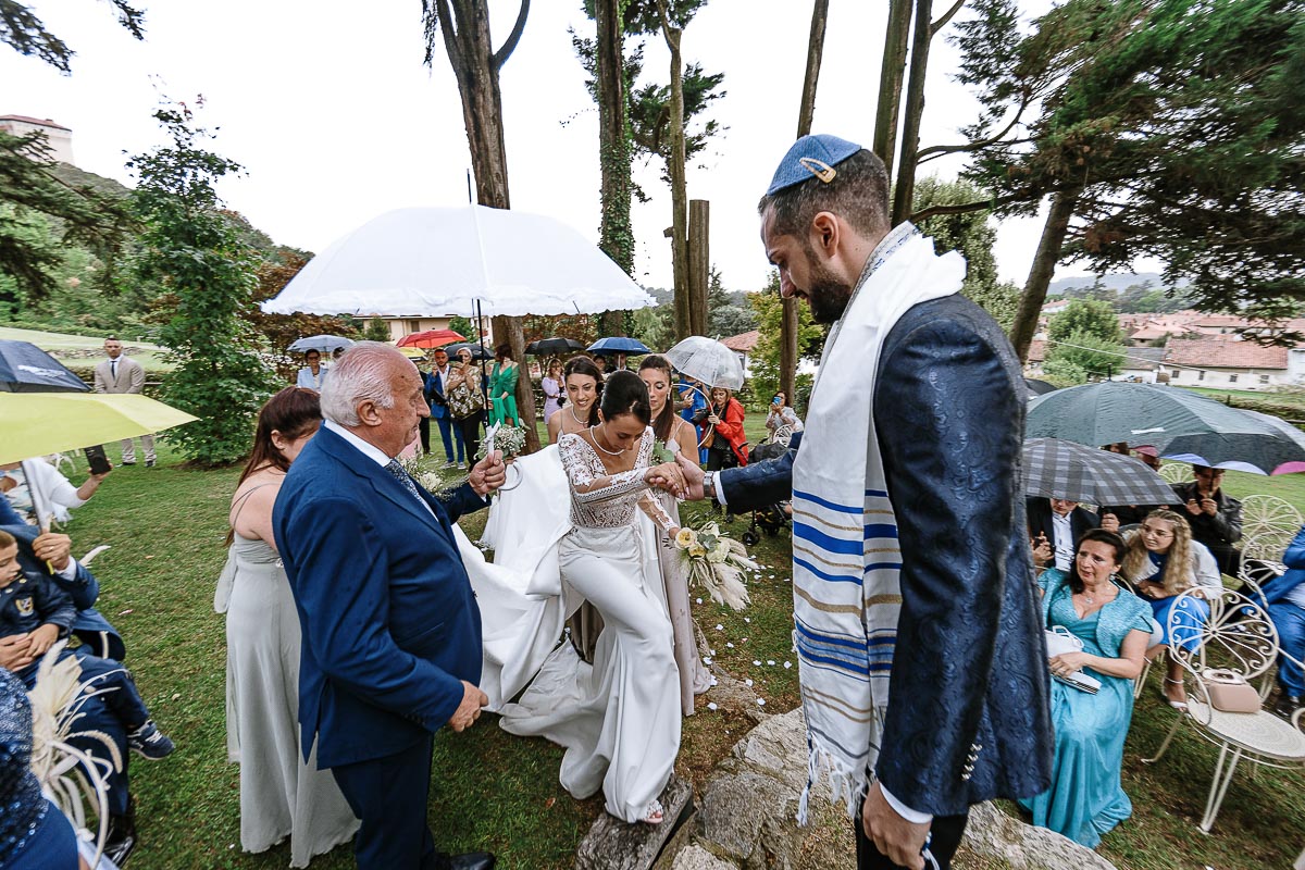 Fotografo Matrimonio Lago di Viverone, Tenuta Variselle. Cerimonia religiosa secondo il rito della Chiesa di Antiochia. Lo sposo aiuta la sposa a salire dove ci sarà la cerimonia.