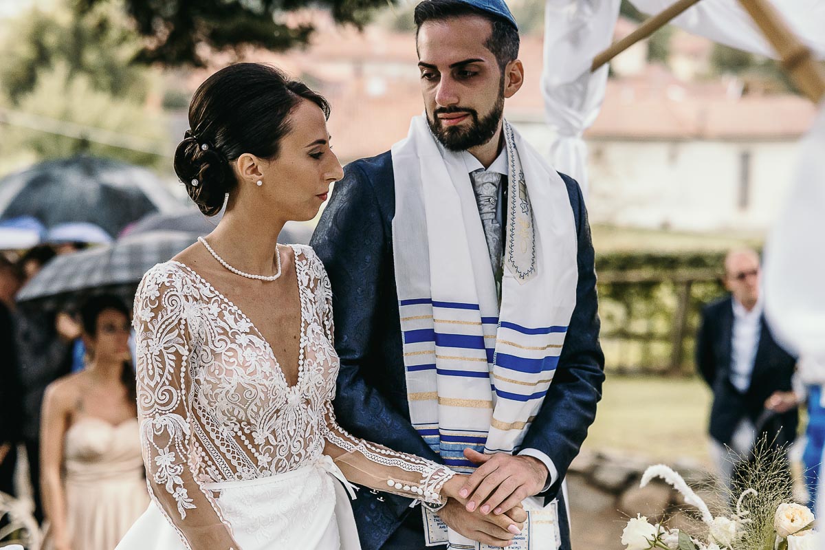 Fotografo Matrimonio Lago di Viverone, Tenuta Variselle. Cerimonia religiosa secondo il rito della Chiesa di Antiochia. Sposi si tengono per mano.
