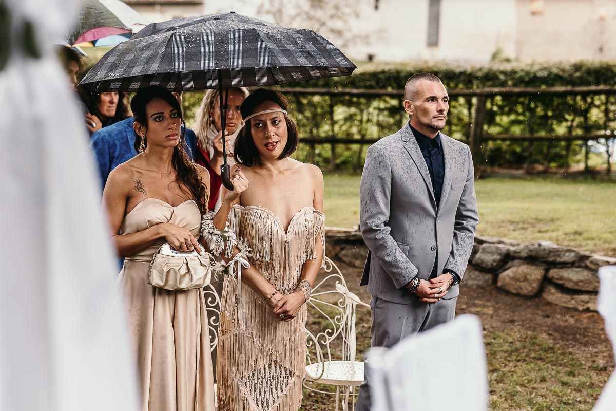Fotografo Matrimonio Lago di Viverone, Tenuta Variselle. Cerimonia religiosa secondo il rito della Chiesa di Antiochia. Sorelle della sposa sotto l'ombrello.