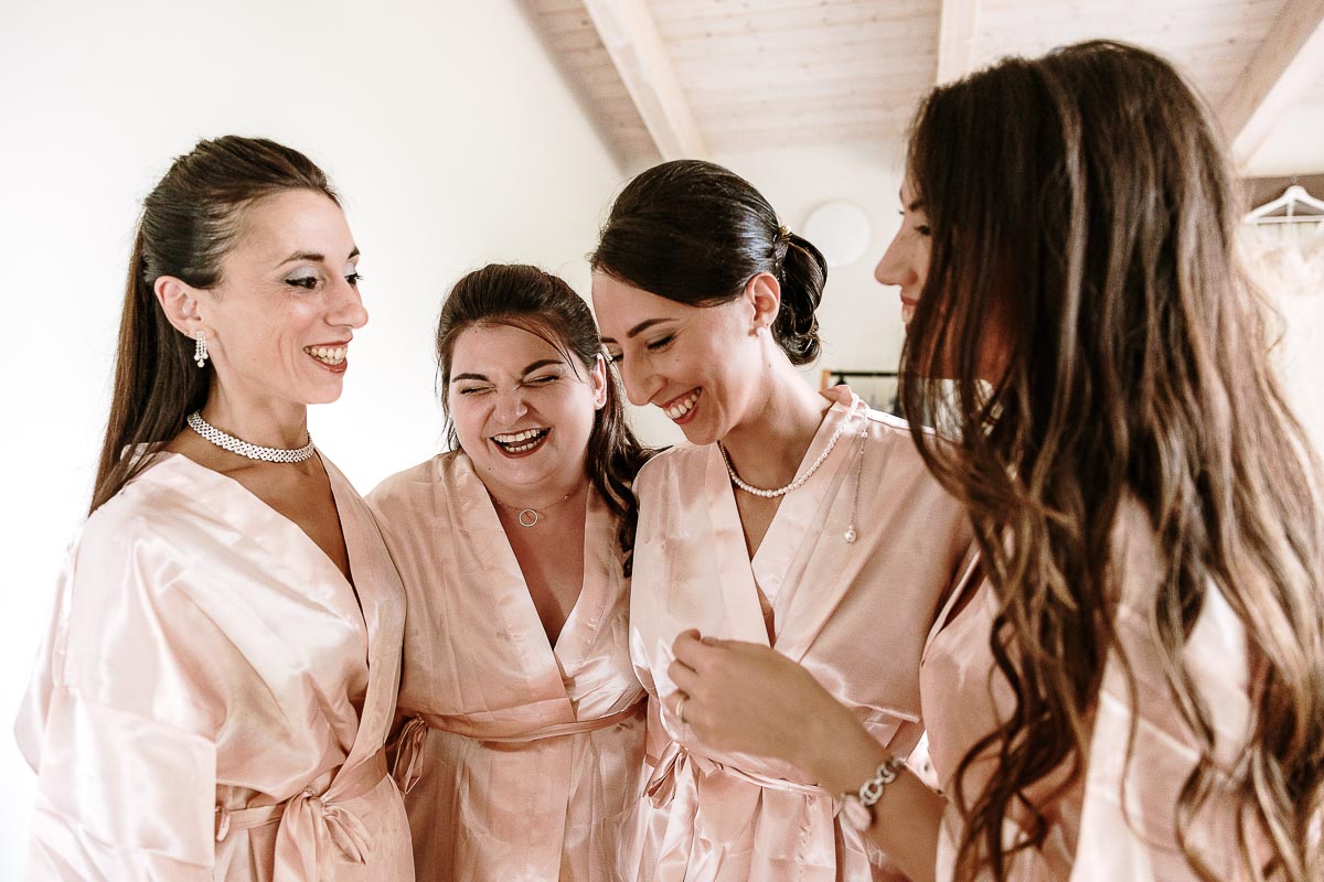 Fotografo Matrimonio Lago di Viverone, Tenuta Variselle. Preparazione della sposa. Sposa con le damigelle ridono.