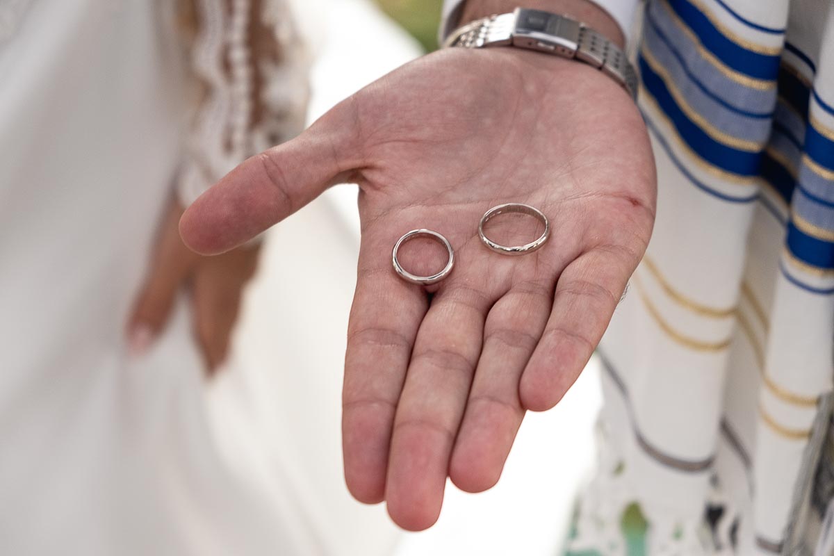 Fotografo Matrimonio Lago di Viverone, Tenuta Variselle. Cerimonia religiosa secondo il rito della Chiesa di Antiochia. Sposo mostra gli anelli sul palmo della mano.